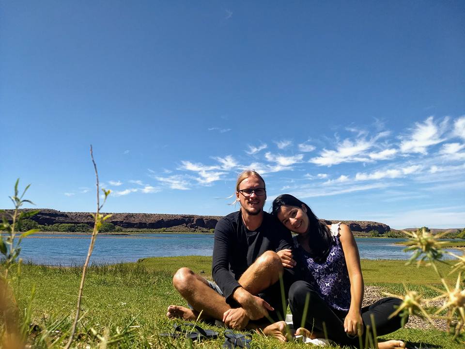 A man and a woman sitting in front a river 