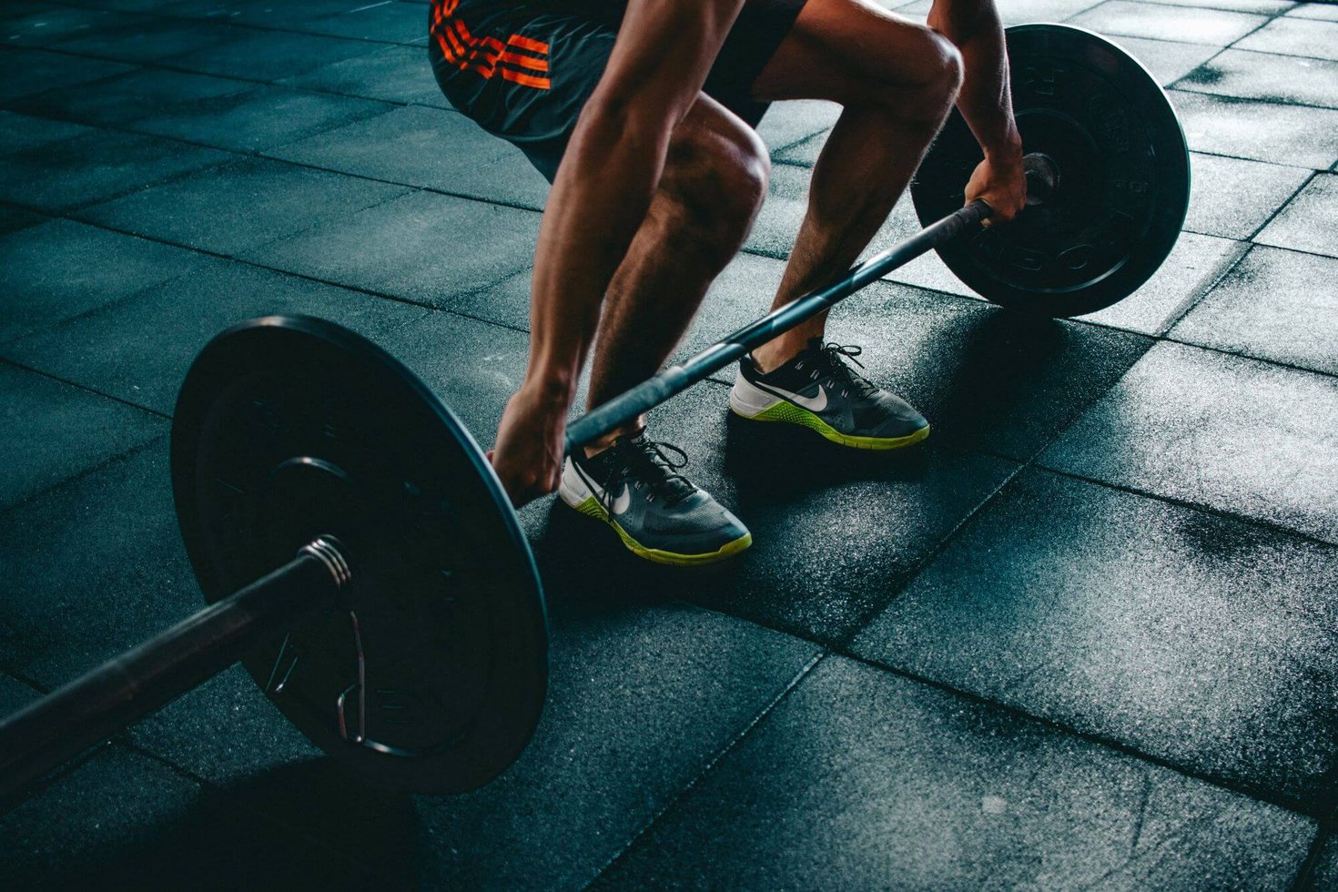 A man gripping his hands around a barbell