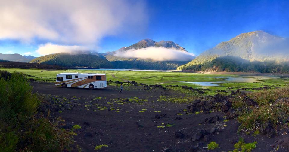 A parked RV in front of a mountain range